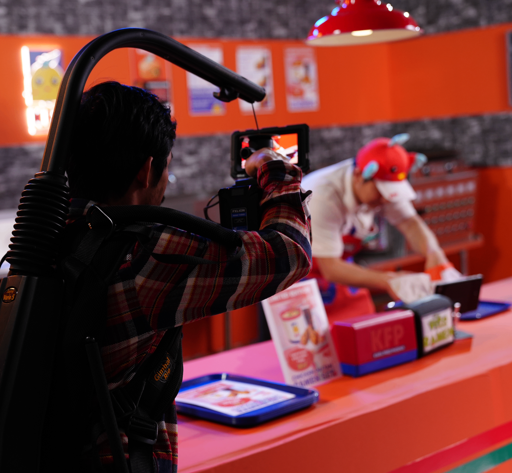 Behind the scenes — camera operator filming inside a bright Vite Ramen counter location